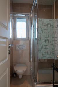 a bathroom with a toilet and a glass shower at VDL Apartments in Trogir