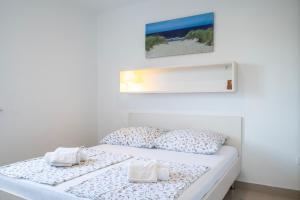 a bedroom with a bed with two towels on it at VDL Apartments in Trogir