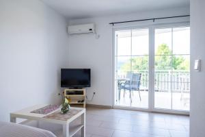 a living room with a tv and a sliding glass door at VDL Apartments in Trogir