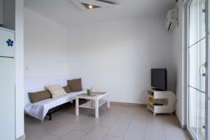 a white living room with a couch and a tv at VDL Apartments in Trogir