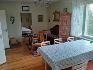 een woonkamer met een tafel en stoelen en een bank bij Ugglebo, stuga in Nauvo