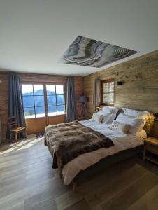 a bedroom with a large bed with a wooden wall at La Boutame : chalet au pied des pistes à Villard Reculas in Villard-Reculas