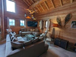 a living room with a couch and furniture in a cabin at La Boutame : chalet au pied des pistes à Villard Reculas in Villard-Reculas