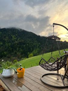 a swing on a deck with a view of a mountain at Mitarbi Silence - cozy holiday cottages in mountains in Borjomi