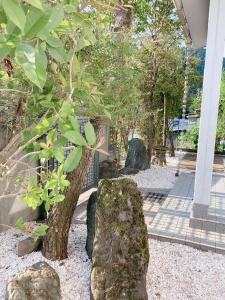 a garden with rocks and a tree and a building at 川辺-KAWABE-BBQ-川遊び-fishing in Hanno