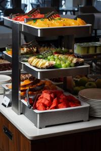 a buffet with several trays of different types of food at Hotel California by Aycon in Sveti Stefan