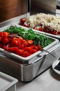 two trays of tomatoes and vegetables on a counter at Hotel California by Aycon in Sveti Stefan