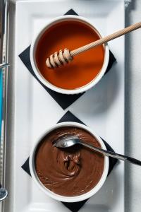 two bowls of chocolate pudding on a tray with a spoon at Hotel California by Aycon in Sveti Stefan