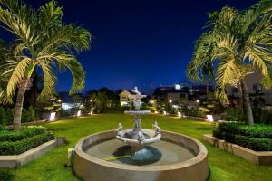uma fonte num parque com palmeiras à noite em Golden Sun Hotel em Vientiane