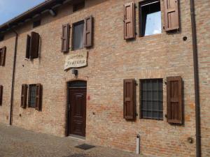 un bâtiment en briques avec des portes et des fenêtres marron dans l'établissement Casolare Fratina, 