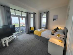 a bedroom with a bed and a flat screen tv at Beach Hotel Torbay in Paignton