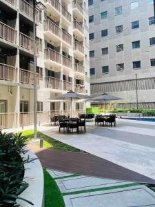 a courtyard with tables and umbrellas in a building at LuxeRN Suite at S Residences in Manila