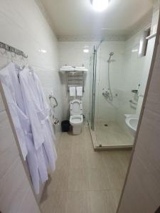 a bathroom with a toilet and a shower and towels at Chorsu Inn in Tashkent
