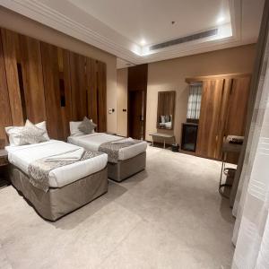 メッカにあるMidan Hotel & Suites Al Aziziyaのベッドルーム(ベッド2台、テレビ付)