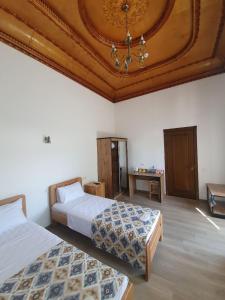 una camera con due letti e un soffitto a cassettoni di Chorsu Inn a Tashkent