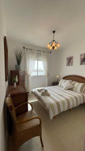 una camera con un grande letto e una sedia di Apartment Attico ad Ayamonte