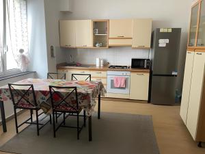 a kitchen with a table with chairs and a refrigerator at Dalla Laretta di fronte all Acquario di Genova in Genoa