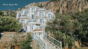 a white building with stairs in front of a mountain at Lavanta Butik Otel Turunc in Turunç
