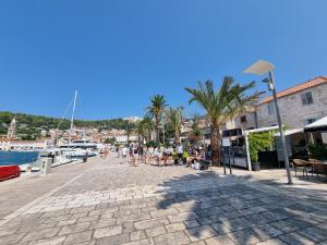 a group of people walking on a sidewalk near a harbor at Studio Riva in Hvar