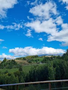 a view of a hill with a blue sky and clouds at AGLAS CHALET in Moieciu de Jos