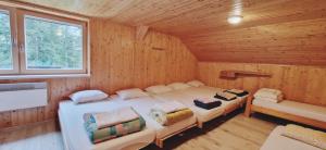 sypialnia z 2 łóżkami w drewnianym domku w obiekcie Mountain hut Dom pod Storžičem w mieście Tržič