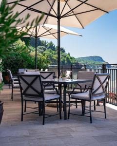 a table and chairs with an umbrella on a patio at Hotel California by Aycon in Sveti Stefan