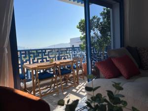 een woonkamer met een tafel en stoelen op een balkon bij Luxus-Unterkunft mit Bergblick! in Martil