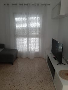 - un salon avec une télévision et un canapé dans l'établissement Apartamento Juan, à Vejer de la Frontera