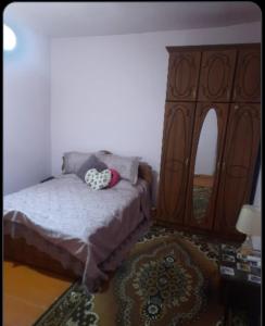 1 dormitorio con 1 cama y un gran armario de madera en MyhomeIsYourhome, en Hors