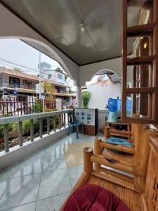 a room with a balcony with a view of a building at Ohlala Hostel in Moalboal