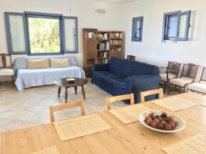 a living room with a blue couch and a table at Aegina Vagia Sea Breeze Vacation Villa in Vaia