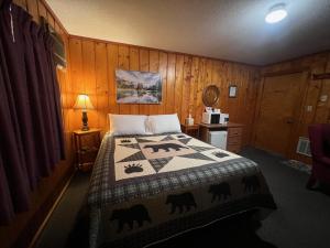 a bedroom with a bed with a quilt on it at Cedars Motel in Saint Ignace