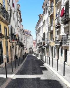 uma rua vazia numa cidade com edifícios altos em Alfama Valle em Lisboa