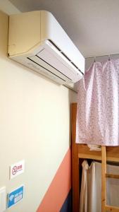 a room with a bed with a ceiling with a window at Fukuoka Guest House Jikka in Fukuoka