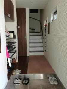 a hallway with a bunch of shoes on the floor at Fukuoka Guest House Jikka in Fukuoka