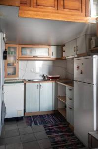 a kitchen with white cabinets and a white refrigerator at Το παραδοσιακό σπίτι του Φτούλη! in Skiros