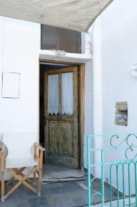 a room with a wooden door and a chair and a door at Το παραδοσιακό σπίτι του Φτούλη! in Skiros