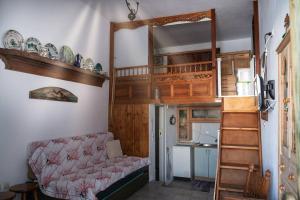 a living room with a loft bed and a couch at Το παραδοσιακό σπίτι του Φτούλη! in Skiros