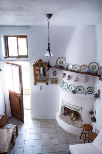 a room with a fireplace with plates on the wall at Το παραδοσιακό σπίτι του Φτούλη! in Skiros +6 photos