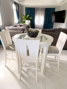 einen weißen Tisch und Stühle im Wohnzimmer in der Unterkunft Home away from home in Christchurch