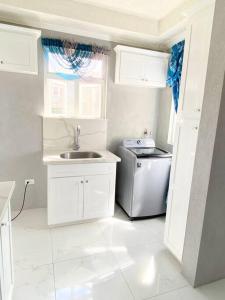 a small kitchen with a sink and a refrigerator at Home away from home in Christ Church