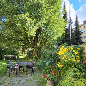 een tuin met een tafel, stoelen en bloemen bij Peaceful and beautiful apartment in Hämeenlinna in Hämeenlinna