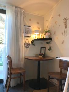 ワナカにあるAlpine View Lodgeのテーブルと椅子2脚、窓が備わる客室です。