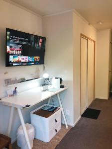 a room with a desk with a tv on the wall at Alpine View Lodge in Wanaka
