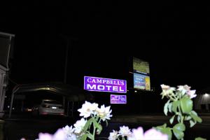 a sign that says campbells motel with white flowers at Campbell's Motel Scottsburg in Scottsburg