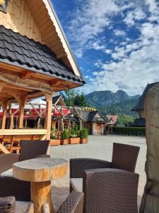 a patio with a table and chairs and mountains at Willa Tatrzański Zomecek in Kościelisko