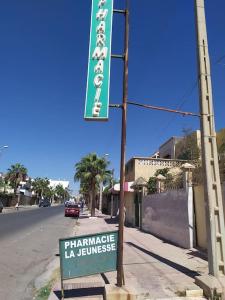 un cartel en un poste al lado de una calle en Flat Al farabi, en Agadir