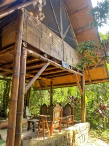 a wooden pergola with chairs and tables on a patio at Sitio Simple Life in Ubatuba