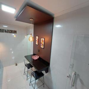 a bathroom with a table and chairs and a shower at Casa Nova Marilea in Rio das Ostras