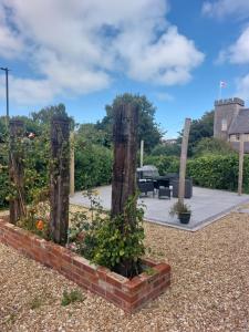 a garden with wooden posts and plants in a yard at Spacious, modern first floor flat near beach and ferry in East Cowes